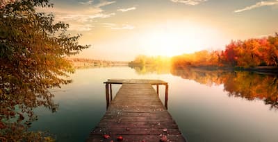 A bridge leading to a lake at sunset. Anxiety can feel lonely without support.